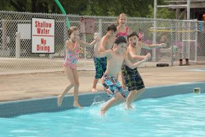 Kids jump into the pool at highland pines campground in Belwood, Ontario.